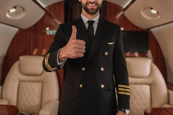 Cropped view of smiling pilot of private jet showing thumb up — Stock Photo