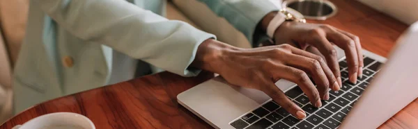 Cropped view of african american businesswoman typing on laptop, panoramic shot — Stock Photo