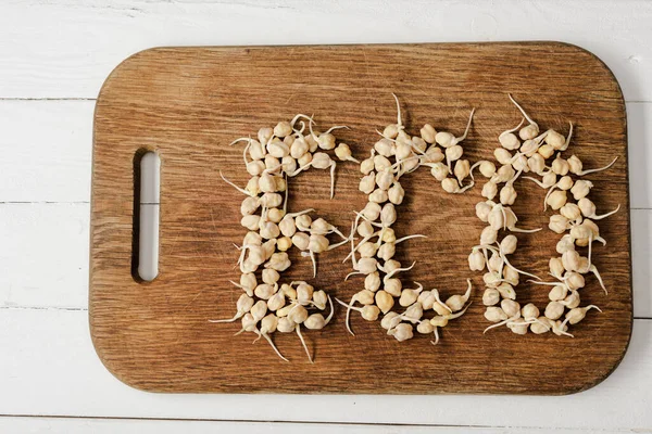 Top view of word eco made of sprouts on cutting board on white wooden surface — Stock Photo
