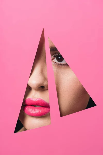 Faccia femminile con labbra rosa attraverso fori triangolari in carta — Foto stock