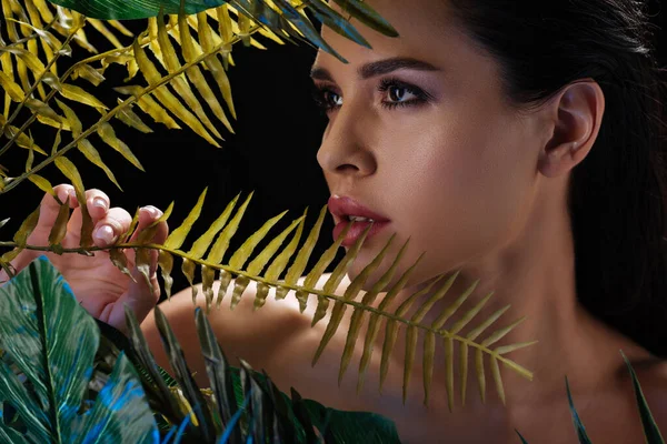 Retrato de mujer hermosa con hojas aisladas en negro - foto de stock