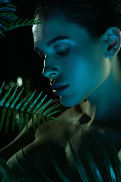 Belle femme aux feuilles vertes isolées sur noir — Photo de stock