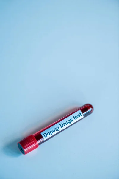 Top view of glass test tube with blood sample and doping drugs test lettering on blue — Stock Photo