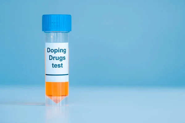 Container with urine sample and doping drugs test lettering on blue — Stock Photo
