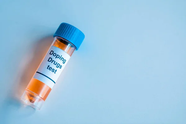 Top view of container with sample and doping drugs test lettering on blue — Stock Photo