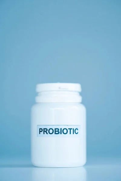 Frasco blanco con letras probióticas en azul - foto de stock