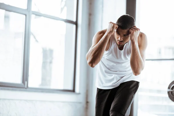 Handsome fighter with clenched fists training in sports center — Stock Photo