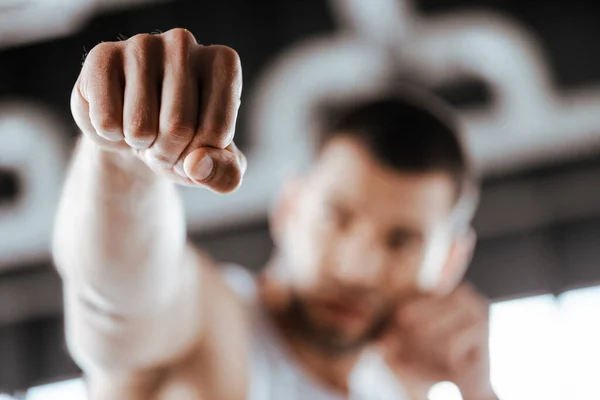Selective focus of fighter with clenched fist training in sports center — Stock Photo