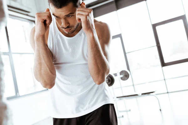 Selective focus of bearded fighter with clenched fists training in sports center — Stock Photo