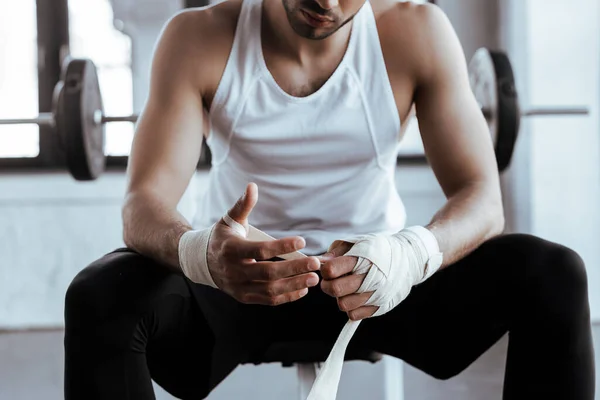 Cropped view of bearded sportsman wrapping hand in sports bandage — Stock Photo