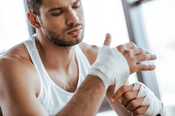Selective focus of sportsman wrapping hand in sports bandage — Stock Photo