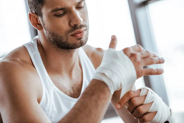 Messa a fuoco selettiva dello sportivo che avvolge la mano nella benda sportiva — Foto stock