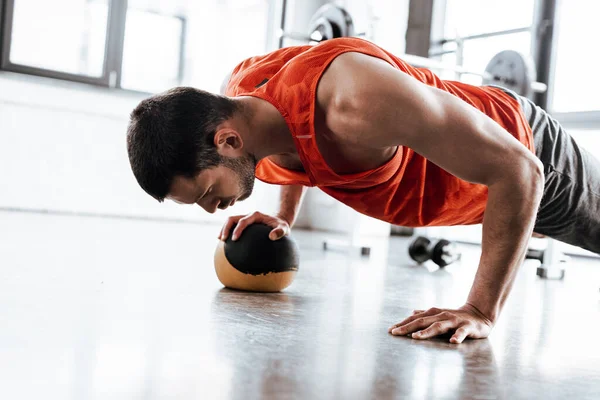 Athletic sportsman doing plank exercising with ball — Stock Photo