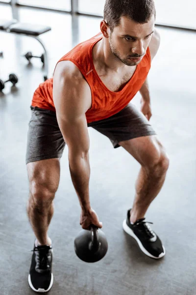 Selective focus of strong man exercising with heavy dumbbell — Stock Photo