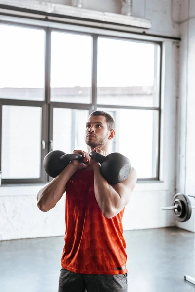 Atlético desportista exercício com pesados halteres — Fotografia de Stock