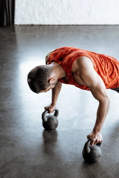 Спортсмен делает упражнения на доске с тяжелыми гантелями — стоковое фото