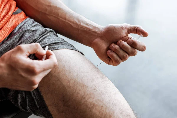 Cropped view of sportsman making forbidden doping injection in leg — Stock Photo