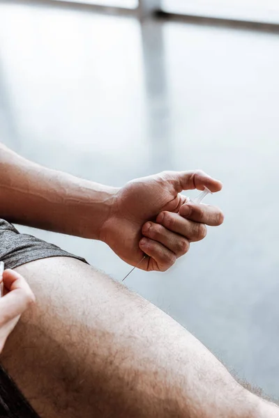 Cropped view of sportsman making doping injection in leg — Stock Photo