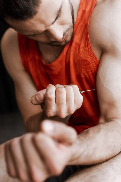 Selective focus of sportsman making doping injection — Stock Photo