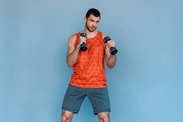 Athletischer Sportler boxt mit Hanteln isoliert auf blau — Stockfoto