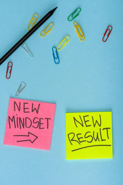 Top view of sticky notes with new mindset and new result lettering with paper clips and pencil on blue — Stock Photo