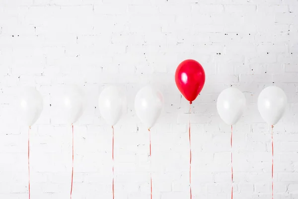Unique red balloon among another on white background — Stock Photo