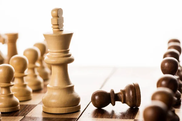 Selective focus of king with pawns on chessboard isolated on white — Stock Photo