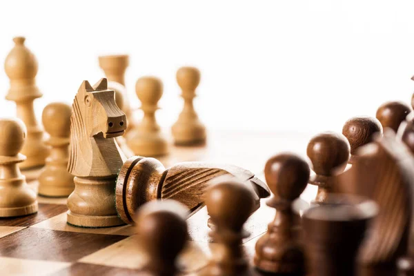 Enfoque selectivo de caballeros y peones en tablero de ajedrez aislado en blanco - foto de stock