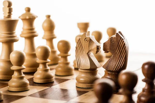 Concentration sélective des pièces d'échecs sur l'échiquier isolé sur blanc — Photo de stock