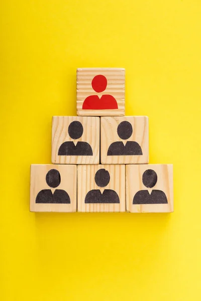 Top view of wooden cubes with red painted man among another on yellow — Stock Photo