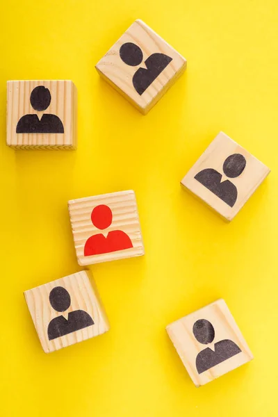 Top view of wooden cubes with unique red painted man among another on yellow — Stock Photo