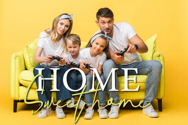 KYIV, UKRAINE - MARCH 4, 2020: cheerful family playing video game with joysticks while sitting on sofa on yellow, home sweet home illustration — Stock Photo