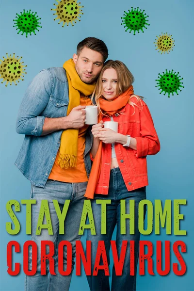 Ill couple in scarves holding cups with hot drinks isolated on blue, bacteria, coronavirus and stay at home illustration — Stock Photo