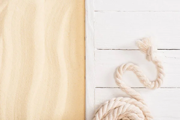 Top view of rope on white wooden planks near sand — Stock Photo