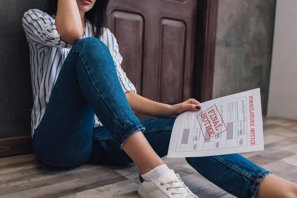 Ausgeschnittene Ansicht einer Frau mit Dokument mit Zwangsvollstreckung und endgültiger Kündigung Schriftzug auf dem Fußboden im Zimmer — Stockfoto