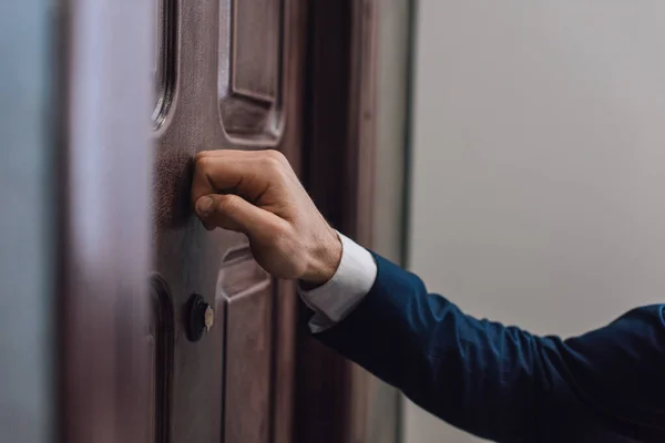 Vista ritagliata del collettore bussare alla porta con mano — Foto stock