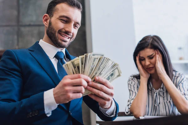 Low angle view of happy collector with money near stressed woman in room — Stock Photo