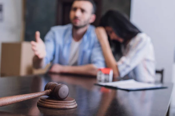 Selective focus of worried bankrupts at table with gavel in room — Stock Photo