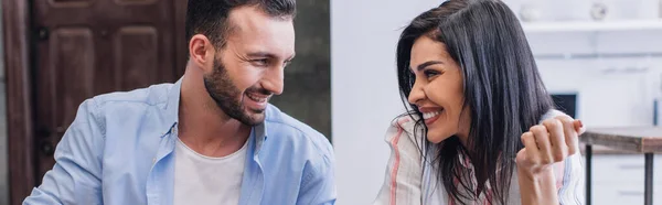 Tiro panorâmico de homem e mulher sorrindo e olhando um para o outro no quarto — Fotografia de Stock