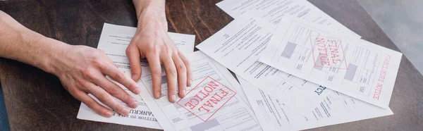 Cropped view of male hands near documents with foreclosure and final notice lettering on table, panoramic shot — Stock Photo