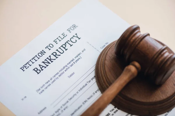 High angle view of gavel on document with petition to file for bankruptcy lettering isolated on beige — Stock Photo