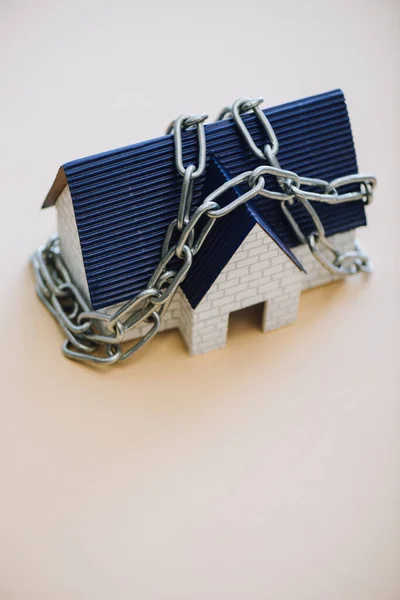 High angle view of house model with chain on white background — Stock Photo