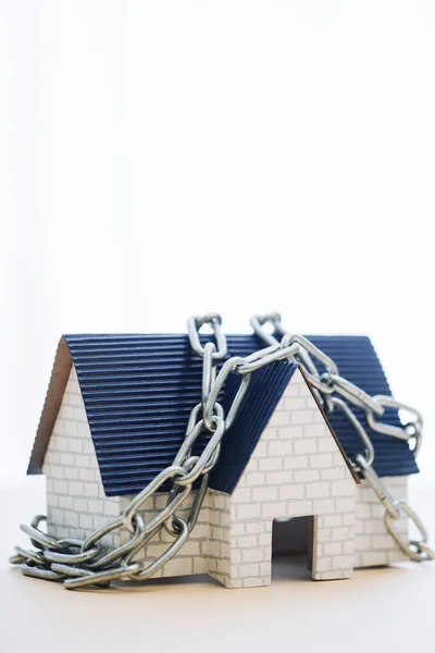 Модель дома с голубой крышей и цепью изолированы на белом — стоковое фото