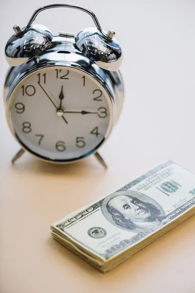 Dollar banknotes and alarm clock on white background — Stock Photo