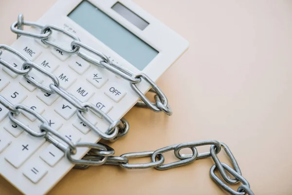 High angle view of calculator with chain on white background — Stock Photo