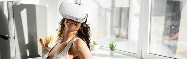 Positive girl using vr headset in kitchen, panoramic shot — Stock Photo