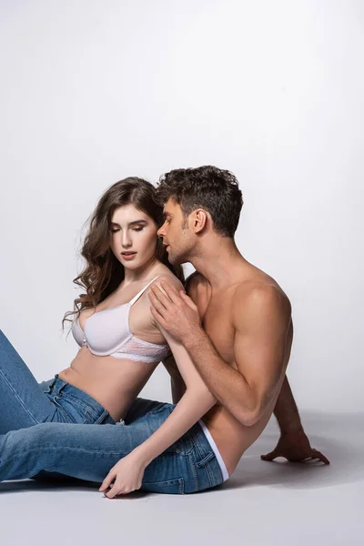 Passionate and shirtless man touching girl in bra on white — Stock Photo