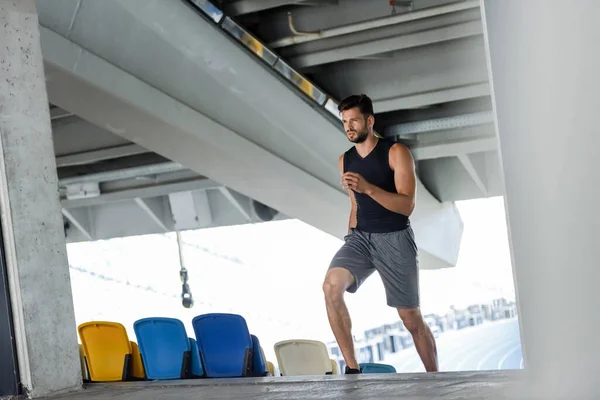 Young sportsman running on stairs at stadium — Stock Photo