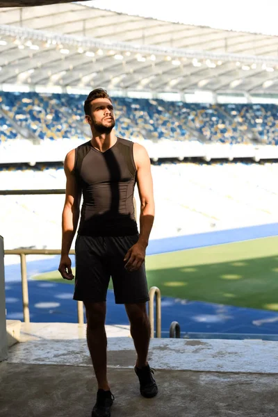 Молодий спортсмен стоїть на сонячному світлі на стадіоні — стокове фото