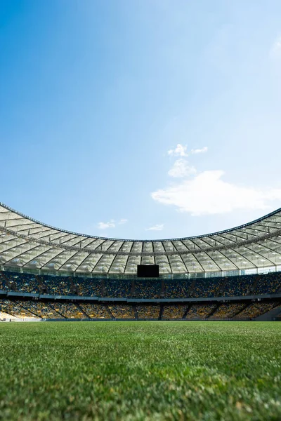 Grassy football pitch at stadium at sunny day with blue sky — Stock Photo
